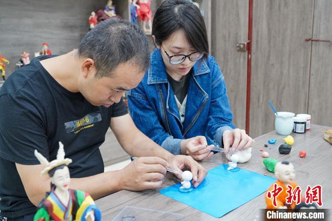 <a target='_blank'  data-cke-saved- >中新社</a>記者(右)現(xiàn)場(chǎng)體驗(yàn)面塑制作過程?！￡悹?zhēng)強(qiáng) 攝