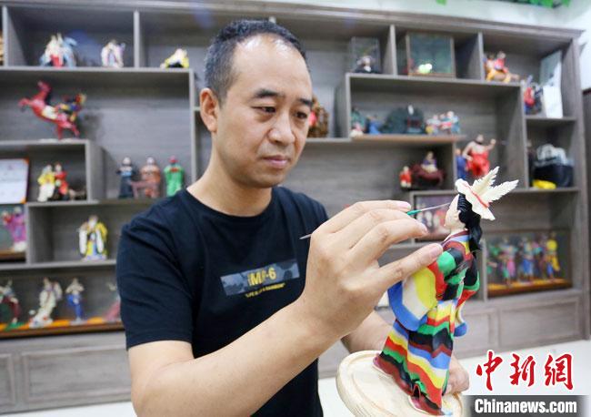 圖為安秋平正在創(chuàng)作代表隴南文縣民俗的《白馬人》作品?！「哒?攝