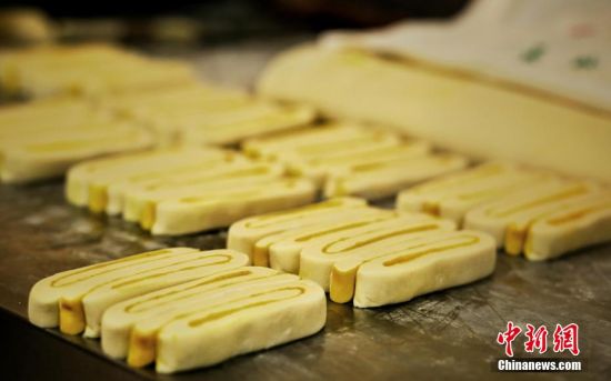 圖為面劑被涂上胡麻油，切成條狀用作月餅的花型制作。張文 攝