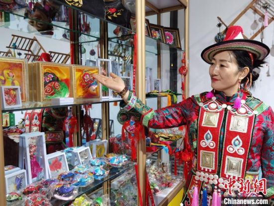 圖為身著民族服飾的隴原巧手展示手工藝品。(資料圖) 徐雪 攝