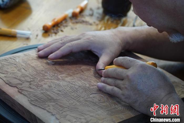 圖為徐晉林湊近木板，近距離制作雕版畫?！【琶赖┰?　攝