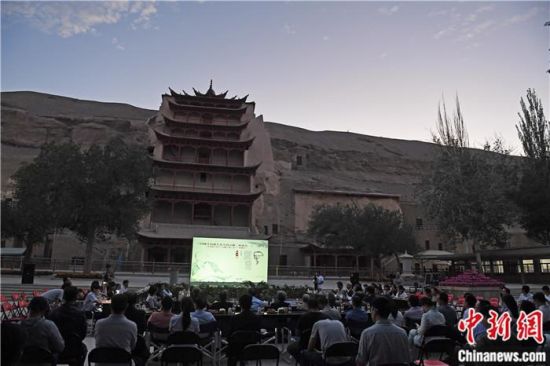 2018年8月，在敦煌莫高窟標(biāo)志性建筑“九層樓”前，《回顧平山郁夫先生的貢獻(xiàn)》座談會(huì)舉行。來(lái)自中日兩國(guó)的專家、學(xué)者共同懷念這位情系敦煌數(shù)十載的繪畫巨匠、中日友好的文化使者、世界文化遺產(chǎn)的守護(hù)者。中新社記者 楊艷敏 攝