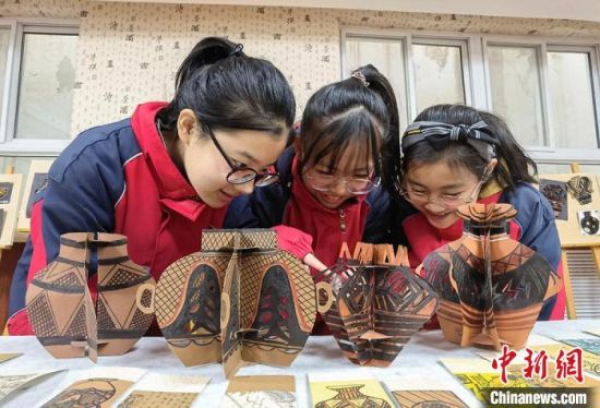 圖為學(xué)生用紙創(chuàng)作的立體彩陶?！⒂裉?攝