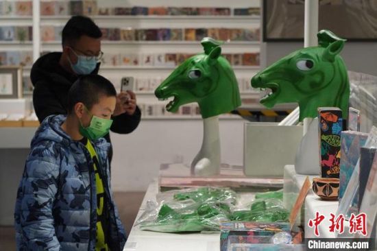 圖為“神馬來了”銅奔馬頭套吸引參觀者駐足?！【琶赖┰?攝