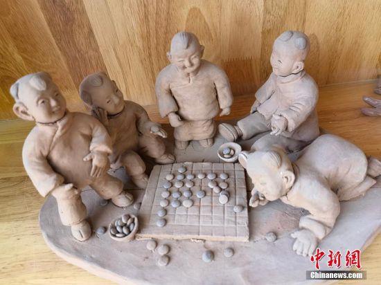 圖為泥塑作品展現(xiàn)下棋場(chǎng)景。 劉玉桃 攝