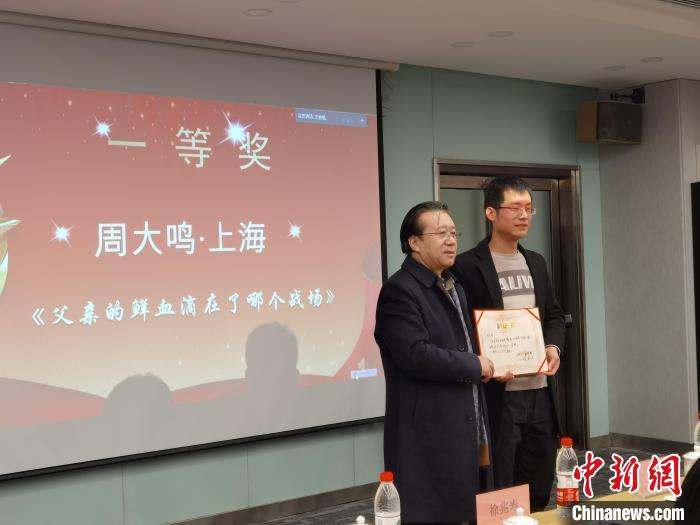 圖為作家、西北師范大學新聞與傳媒學院院長徐兆壽頒發(fā)一等獎證書，代領(lǐng)獎者上臺領(lǐng)獎。　楊娜 攝