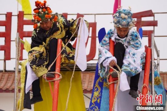 圖為“苦水高高蹺”表演者通過(guò)麻繩將腳固定在腳踏板，并在腿部纏繞六七圈。　九美旦增 攝