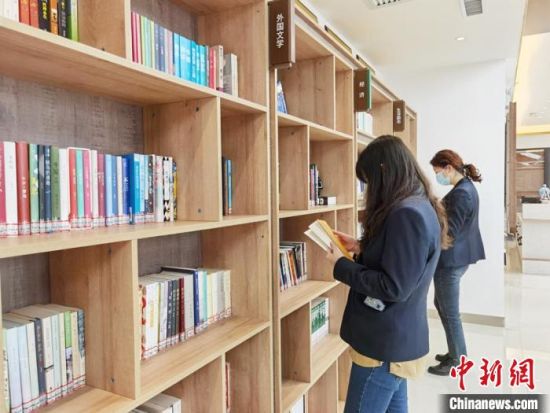 圖為在甘肅公航旅建設(shè)集團有限公司的職工書屋，職工挑選書籍?！⌒煅?攝