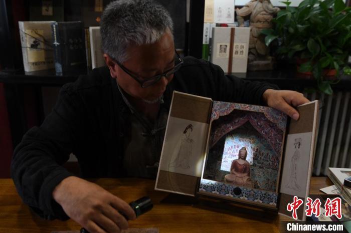 圖為讀者出版集團(tuán)讀者晉林工作室獨立出品人徐晉林，展示互動性強(qiáng)的敦煌題材手工書。(資料圖) 楊艷敏 攝