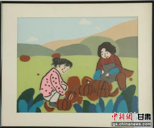 嘉峪關(guān)市新城鎮(zhèn)新城村農(nóng)業(yè)產(chǎn)業(yè)園區(qū)內(nèi)，母女兩人在摘南瓜。刺繡 馬艾米乃 繡稿 敬紅霞