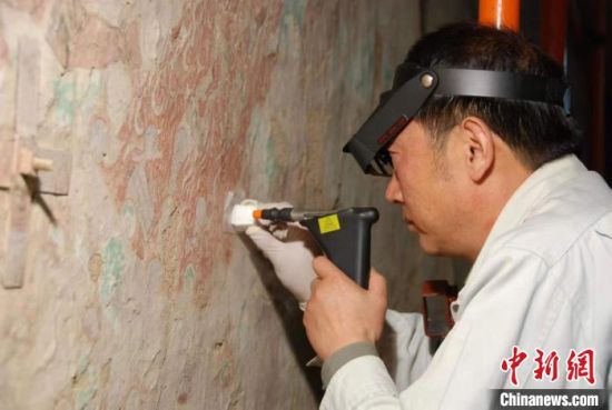 敦煌研究院研究員樊再軒進(jìn)行壁畫(huà)修復(fù)。(資料圖)張?jiān)莆?攝