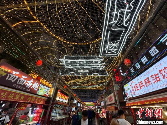 圖為明清街夜市燈光點亮具有武威文化元素的“涼州古城門”彩燈。　戴文昌 攝</p><p>