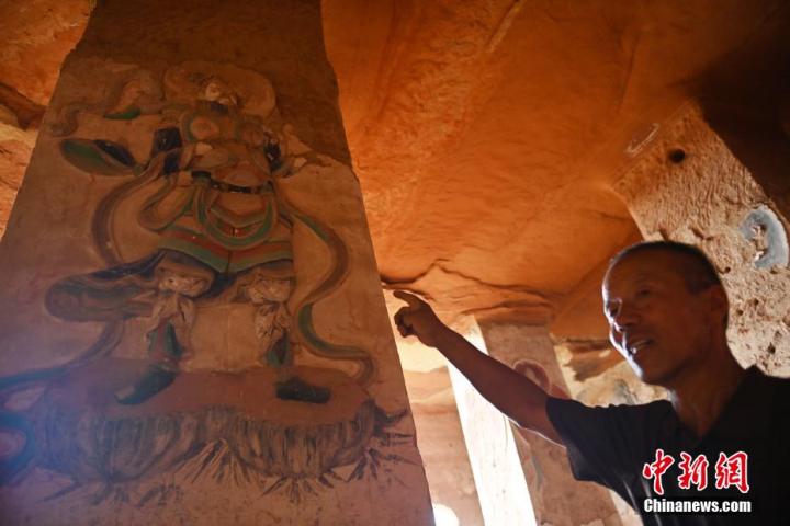 7月15日，甘肅省平?jīng)鍪袥艽h百里石窟長廊羅漢洞石窟內(nèi)，該窟文保員郭建平介紹窟內(nèi)石刻彩繪壁畫。郭建平家中三代人曾自發(fā)保護(hù)羅漢洞石窟。羅漢洞石窟遺存40余個(gè)窟龕，以北魏至清代風(fēng)格為主。中新社記者 李亞龍 攝</p>
<p>