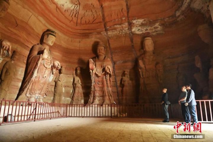 7月15日，游人參觀甘肅省平?jīng)鍪袥艽h百里石窟長廊中的南石窟寺1號窟。百里石窟長廊位于涇川縣境內(nèi)，由512個(gè)石窟、5眼窟中石井組成，現(xiàn)存王母宮石窟、鳳凰山石窟、南石窟寺、丈八寺石窟、羅漢洞石窟、太山寺石窟等規(guī)模較大的石窟群，還有數(shù)量眾多的小石窟群。南石窟寺開鑿于北魏永平三年，其中1號窟屬于大型七佛窟，七佛高達(dá)6米。中新社記者 李亞龍 攝