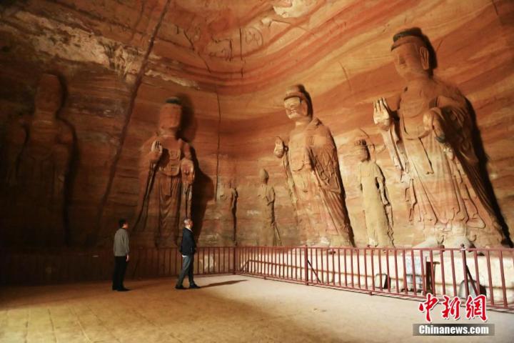 7月15日，游人參觀甘肅省平?jīng)鍪袥艽h百里石窟長廊中的南石窟寺1號窟。百里石窟長廊位于涇川縣境內(nèi)，由512個(gè)石窟、5眼窟中石井組成，現(xiàn)存王母宮石窟、鳳凰山石窟、南石窟寺、丈八寺石窟、羅漢洞石窟、太山寺石窟等規(guī)模較大的石窟群，還有數(shù)量眾多的小石窟群。南石窟寺開鑿于北魏永平三年，其中1號窟屬于大型七佛窟，七佛高達(dá)6米。中新社記者 李亞龍 攝