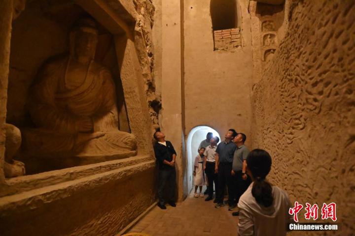 7月15日，游人參觀甘肅省平?jīng)鍪袥艽h百里石窟長廊中的王母宮石窟。百里石窟長廊位于涇川縣境內(nèi)，由512個(gè)石窟、5眼窟中石井組成，現(xiàn)存王母宮石窟、鳳凰山石窟、南石窟寺、丈八寺石窟、羅漢洞石窟、太山寺石窟等規(guī)模較大的石窟群，還有數(shù)量眾多的小石窟群。王母宮石窟又名千佛洞，該窟設(shè)計(jì)宏大，造像生動，窟內(nèi)擁有造像數(shù)百尊，是較為珍貴的佛教文化歷史遺存。中新社記者 李亞龍 攝</p>
<p>