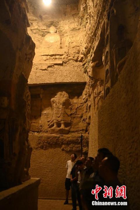 7月15日，游人參觀甘肅省平?jīng)鍪袥艽h百里石窟長廊中的王母宮石窟。百里石窟長廊位于涇川縣境內(nèi)，由512個(gè)石窟、5眼窟中石井組成，現(xiàn)存王母宮石窟、鳳凰山石窟、南石窟寺、丈八寺石窟、羅漢洞石窟、太山寺石窟等規(guī)模較大的石窟群，還有數(shù)量眾多的小石窟群。王母宮石窟又名千佛洞，該窟設(shè)計(jì)宏大，造像生動，窟內(nèi)擁有造像數(shù)百尊，是較為珍貴的佛教文化遺存。中新社記者 李亞龍 攝</p>
<p>
