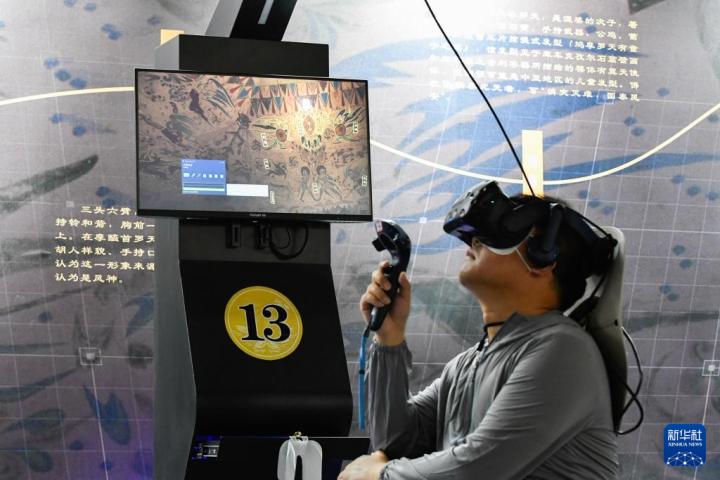 7月22日，游客借助VR設(shè)備沉浸式游覽莫高窟第285窟虛擬場(chǎng)景。新華社記者 郎兵兵 攝